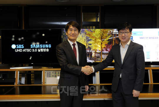 지난 9일 SBS 목동사옥에서 삼성전자와 SBS가 차세대 지상파 UHD 방송 규격인 ATSC 3.0 기술을 통한 실시간 실험 방송에 성공했다. 유준영 삼성전자 영상디스플레이사업부 상무( 오른쪽)와 박영수 SBS 기술본부장(사진 왼쪽)이 악수를 나누고 있다. <삼성전자 제공>